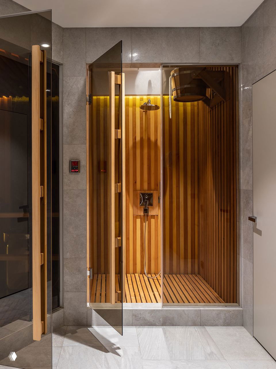 Современная душевая-парная с прозрачной стеклянной дверью, вертикальной деревянной облицовкой и деревянным настилом внутри.