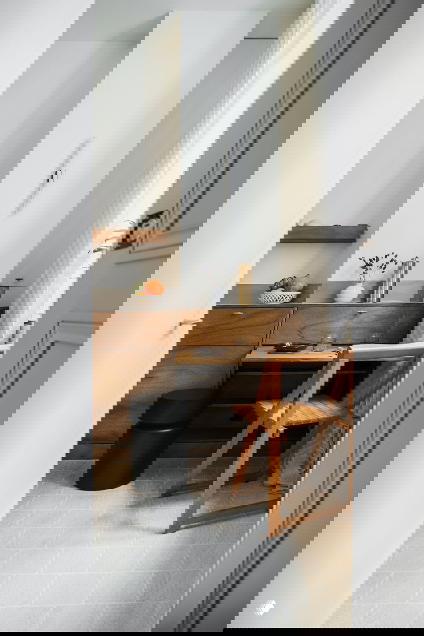 Проход с арочным проёмом, деревянные шкафы и встроенные модули, светлая плитка на полу и мягкая нейтральная палитра интерьера.