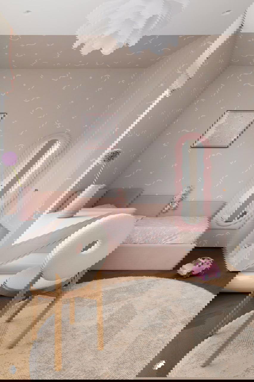 Детская комната в розовой гамме: кровать с низким изголовьем, мягкий круглый ковер и игрушки — тёплая и безопасная атмосфера для ребёнка.