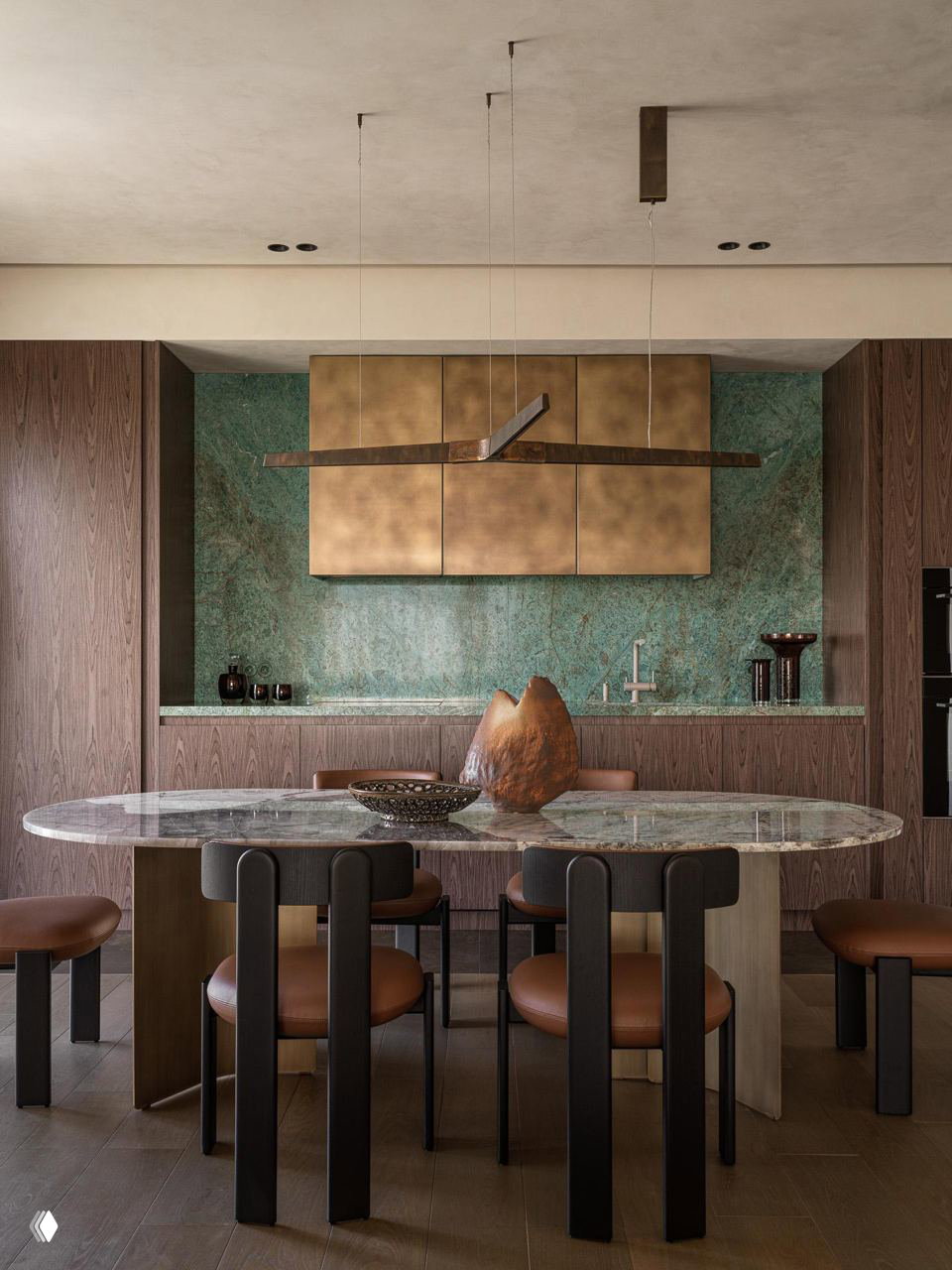 Обеденная зона: овальный стол с зелёным мраморным верхом, бронзовые подвесы и темно‑коричневые деревянные фасады, сочетание благородных материалов.