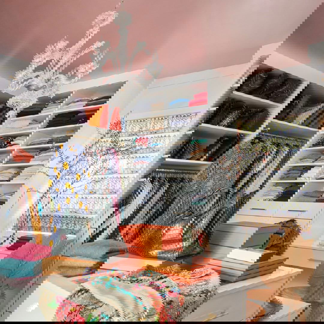 Яркая и насыщенная гардеробная с полками, ящиками и аксессуарами — пример визуально разнообразного, но организованного хранения.