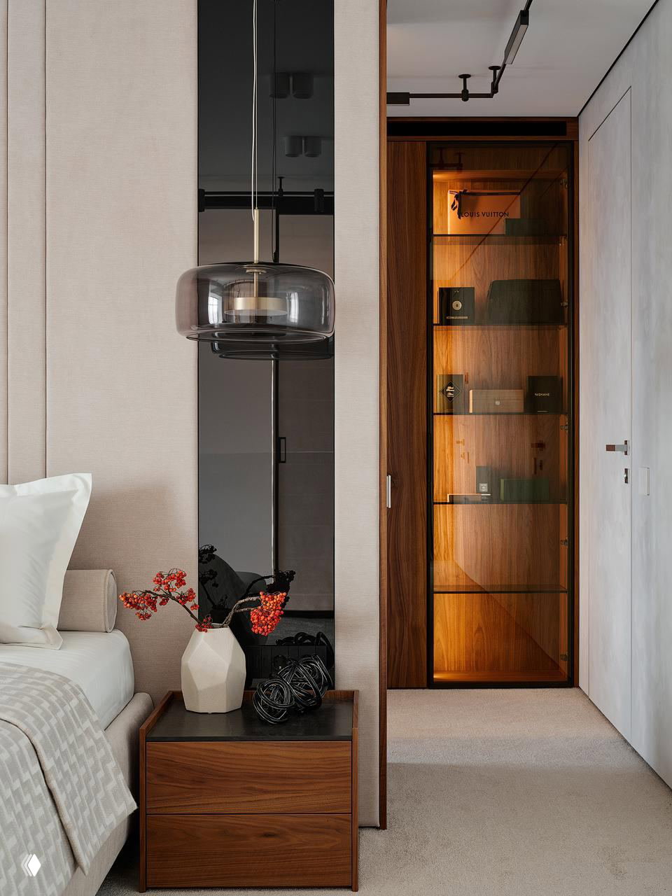 Деталь спальни и прилегающего коридора: деревянные фасады, стеклянные дверцы шкафа с подсветкой и тумбочка с декоративной вазой и аксессуарами.