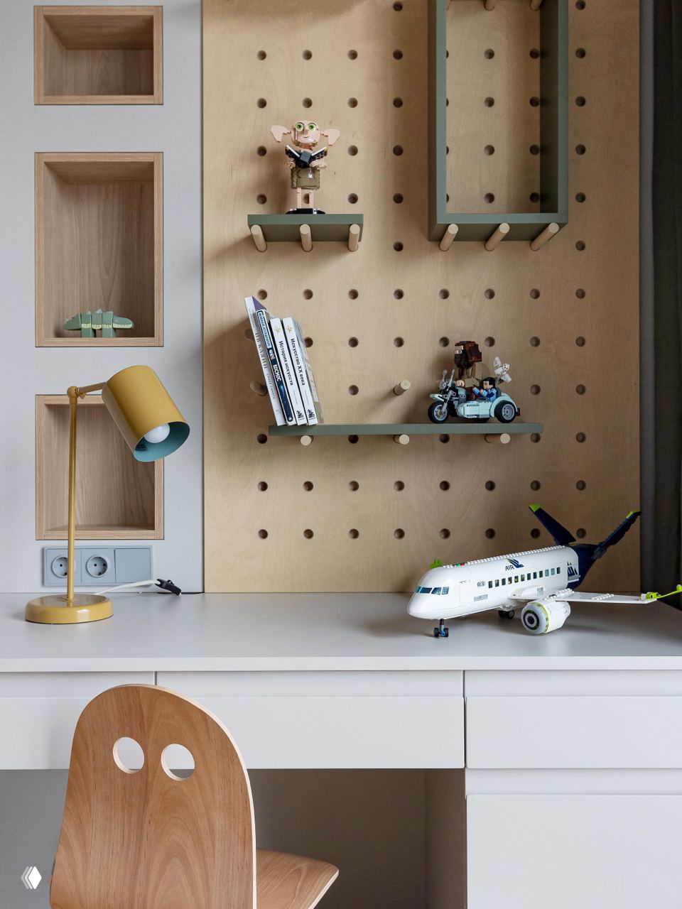 Рабочее место ребёнка с настольной лампой, игрушечным самолётом и перфорированной панелью с полками для книг и мелочей; фото Виталины Ворошкевич.