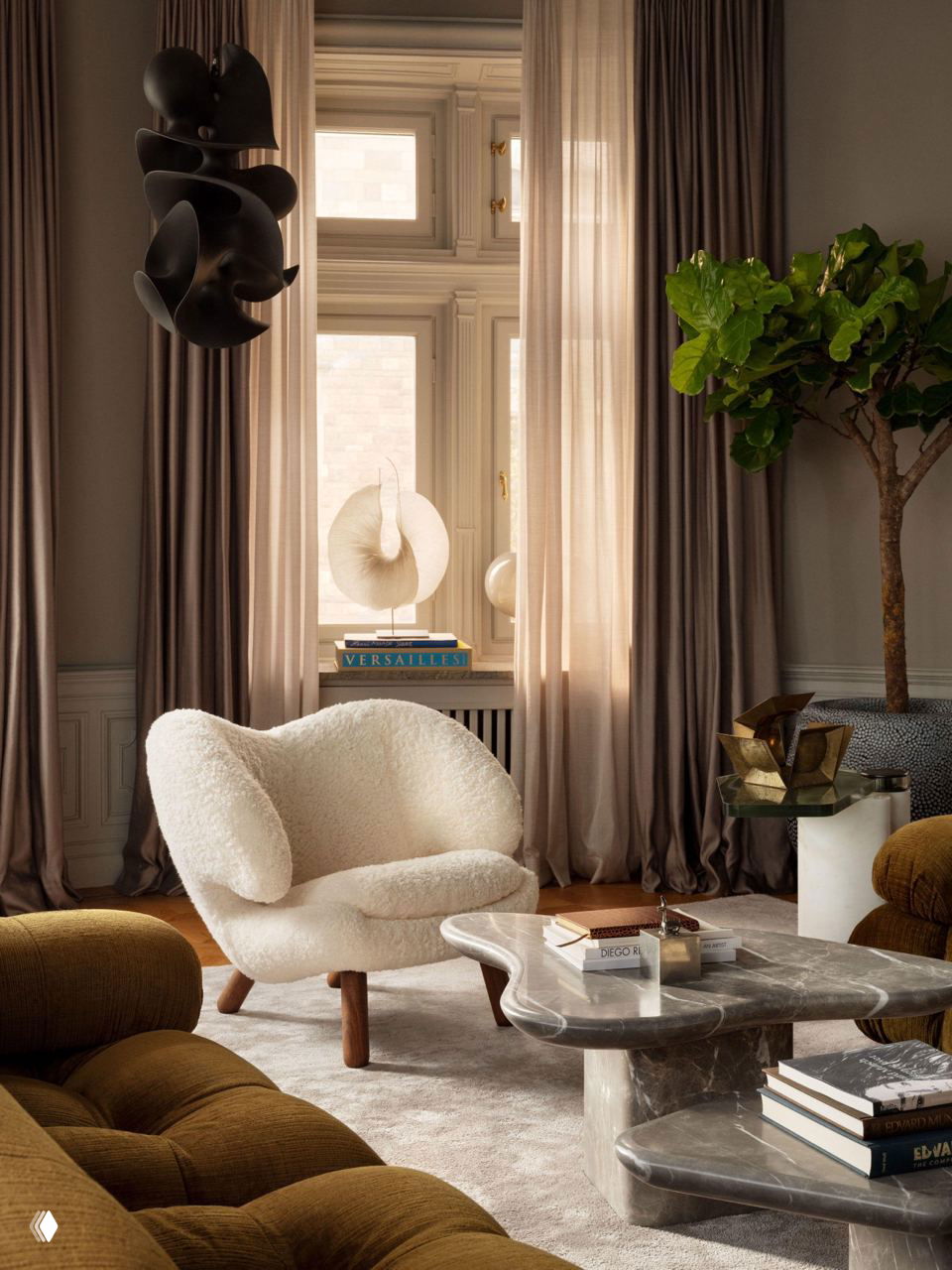 Уютная гостиная с пышным плюшевым креслом, мраморным журнальным столиком и сложным сочетанием тканей и форм на фоне высоких окон и плотных штор.