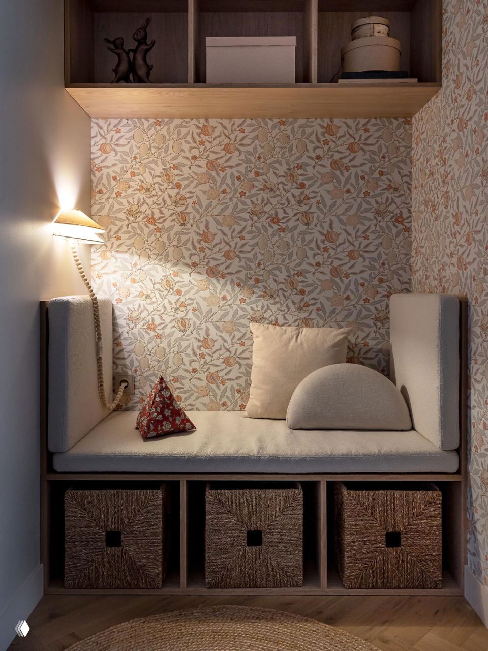 Уютная ниша для чтения с мягкой банкеткой, плетёными корзинами для хранения и обоями с растительным орнаментом в тёплых тонах; фото Виталины Ворошкевич.