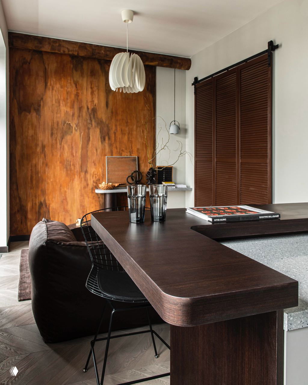 Рабочая зона и кухня с тёплыми коричневыми деревянными поверхностями и тёмными деталями; сочетание текстур дерева и камня в функциональном пространстве.