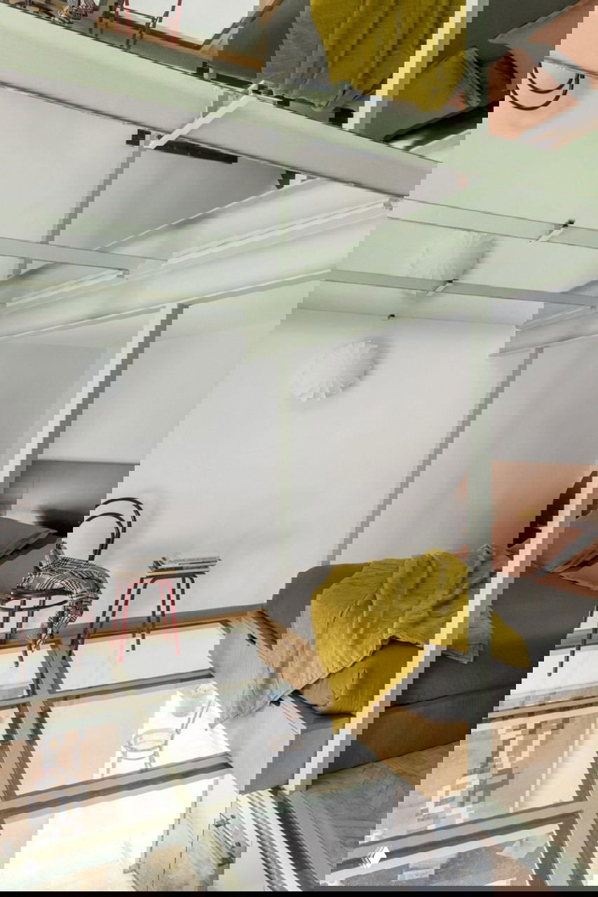 Спальня на стеклянном настиле: кровать на деревянном подиуме над прозрачным полом, отражения в зеркальном потолке создают эффект двойного пространства.