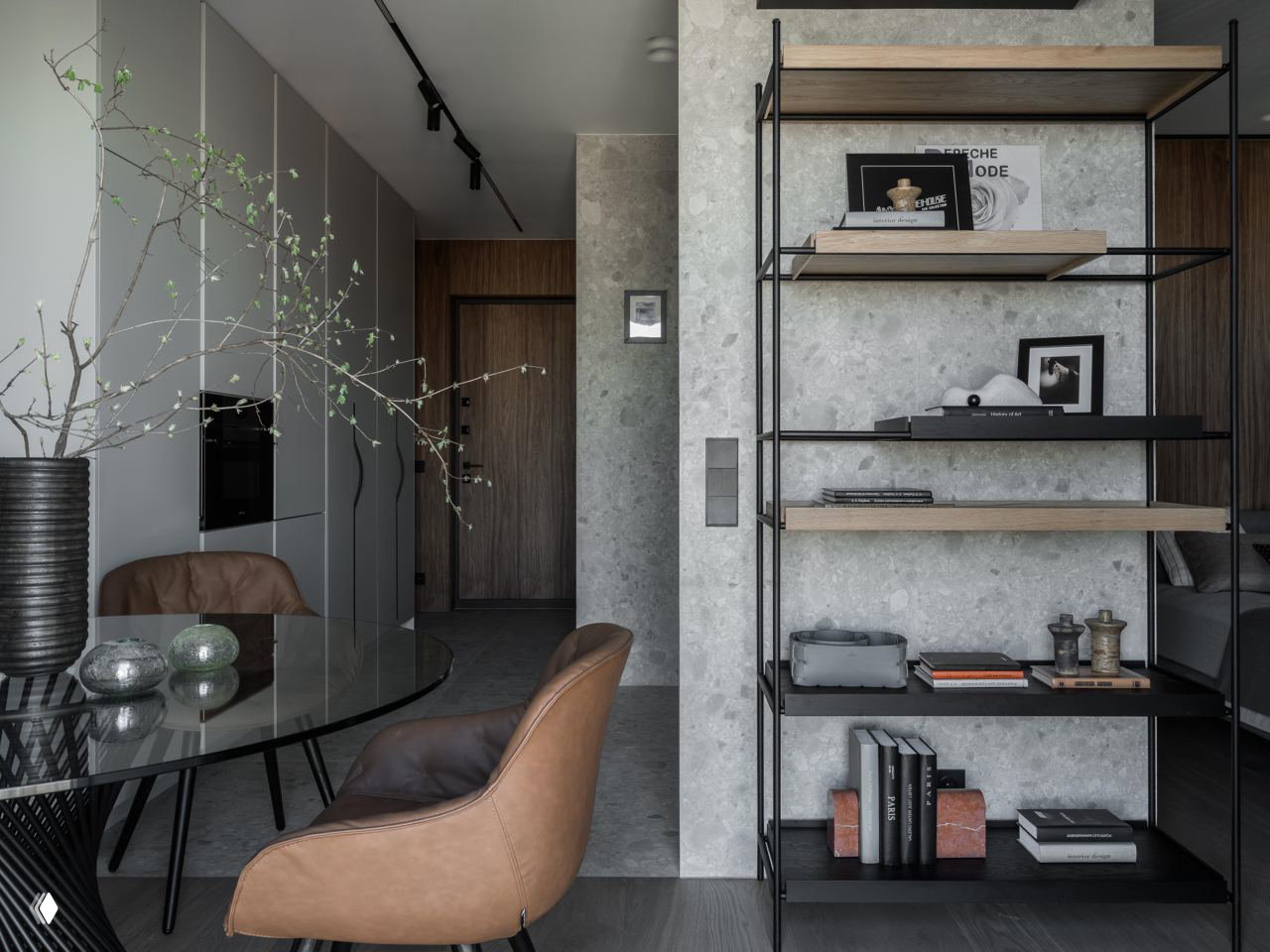 Вид на кухонную и входную зоны: минималистичные фасады, открытые полки и акцентные декоративные предметы в спокойной серой гамме.