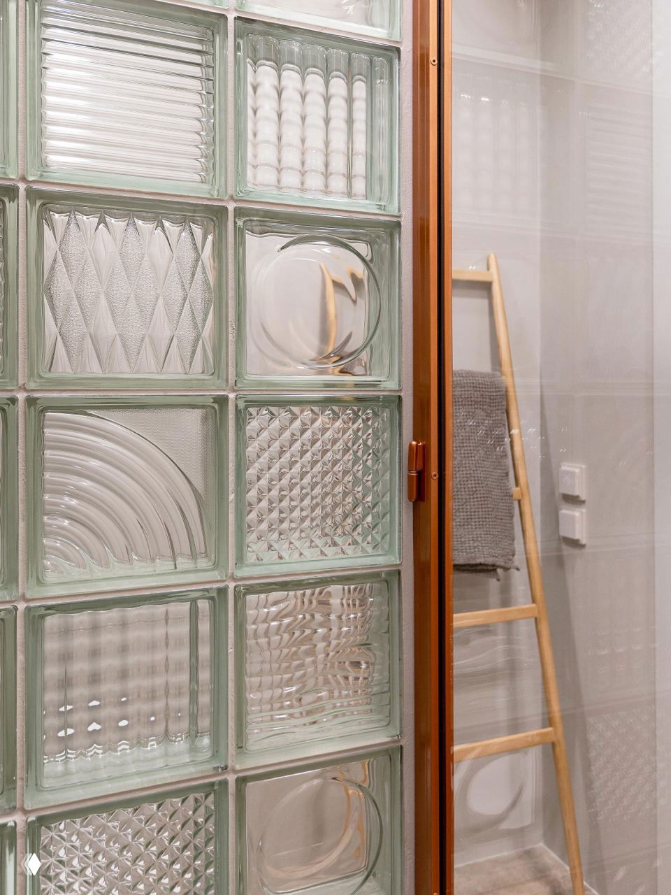 Детали санузла: декоративные стеклоблоки с геометрическим рисунком и деревянная стремянка; минималистичный интерьер с акцентом на текстуру; фото Виталины Ворошкевич.