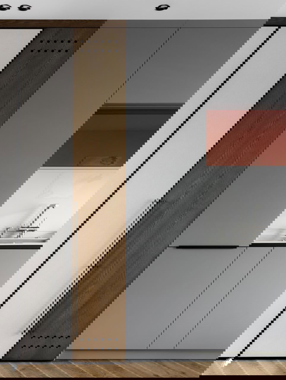 Фрагмент встроенного хранения в квартире 42,5 м²: комбинированные фасады из дерева и матового серого материала, длинная ручка и паркетный пол.