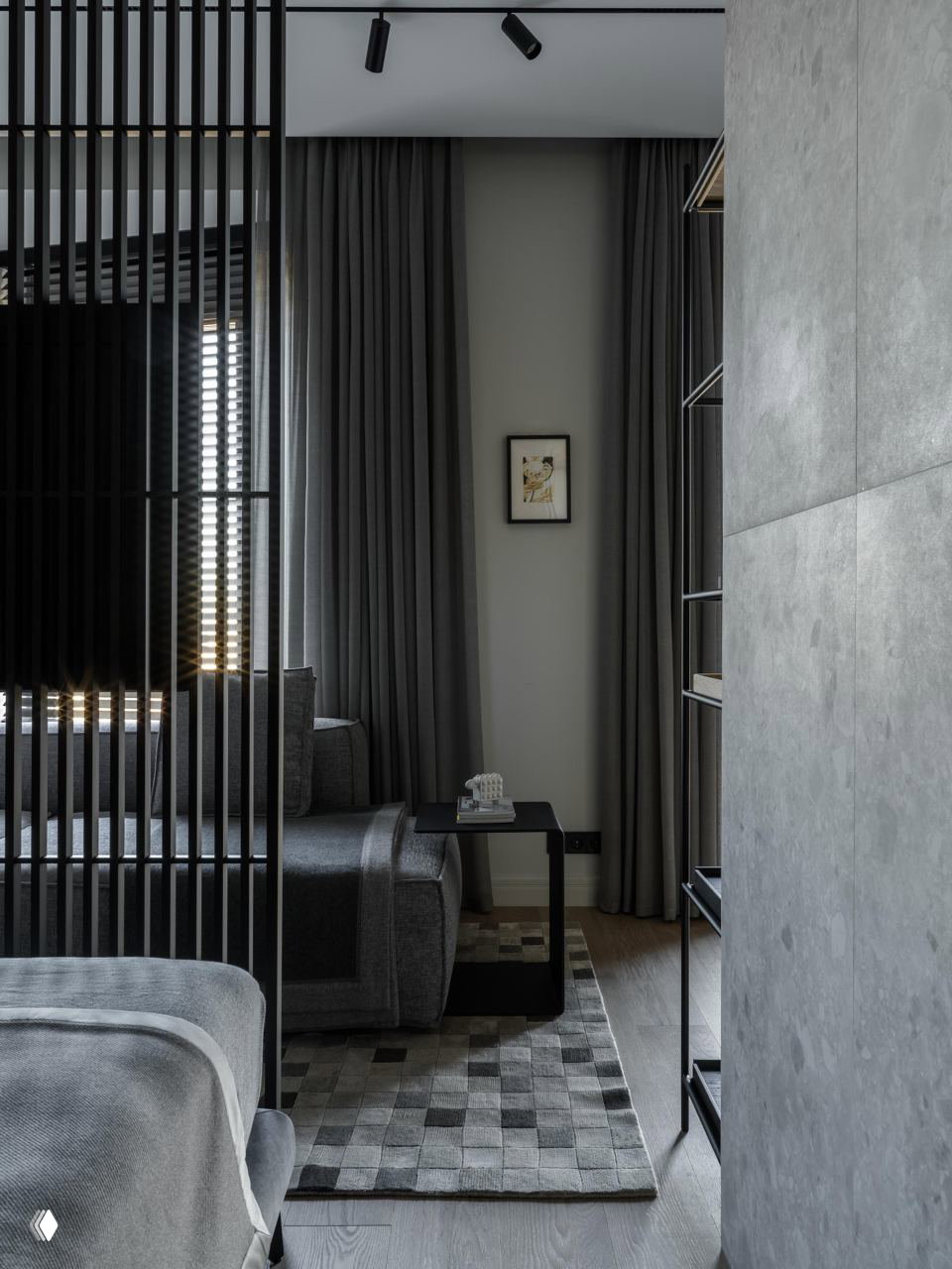 Спальная и гостевая зоны разделены вертикальной рейкой: темные шторы, серая мягкая мебель и текстурный коврик создают уют и приватность.