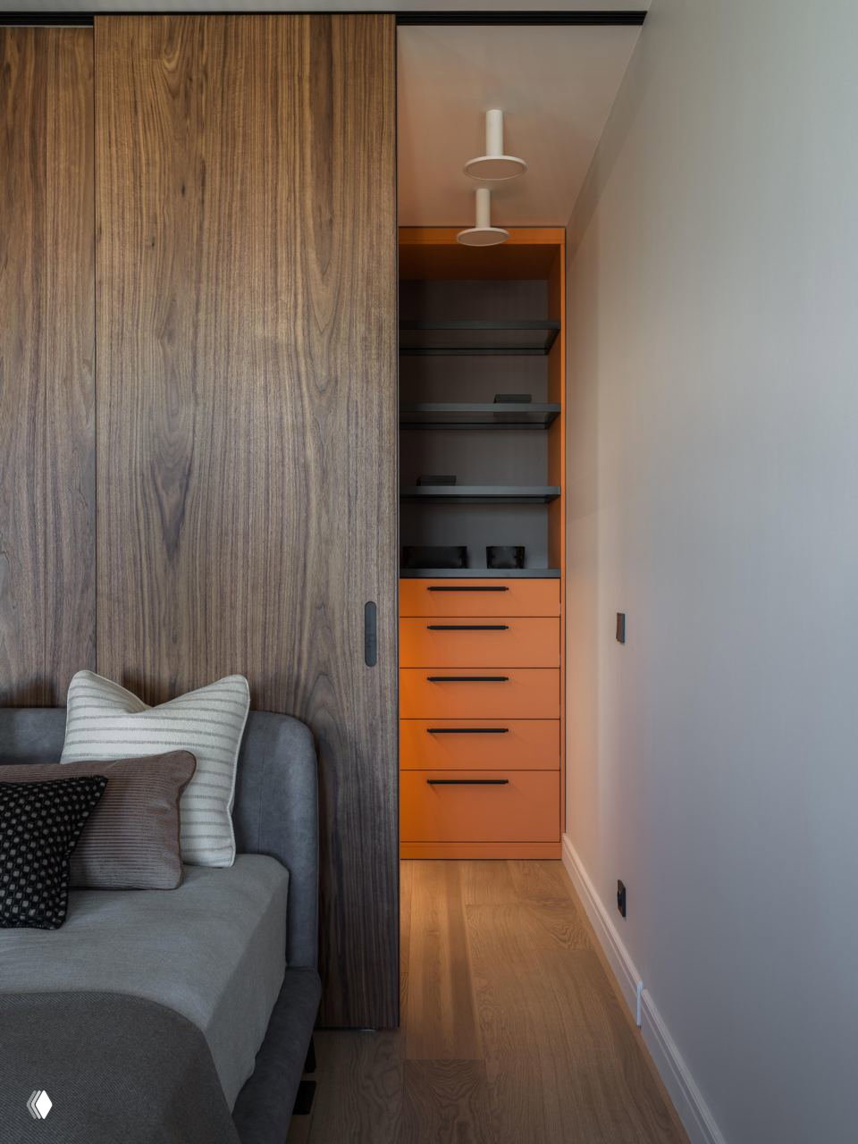 Спальня с раздвижной деревянной перегородкой и ярким оранжевым нишевым хранилищем: акцентный цвет в нейтральной палитре интерьера.