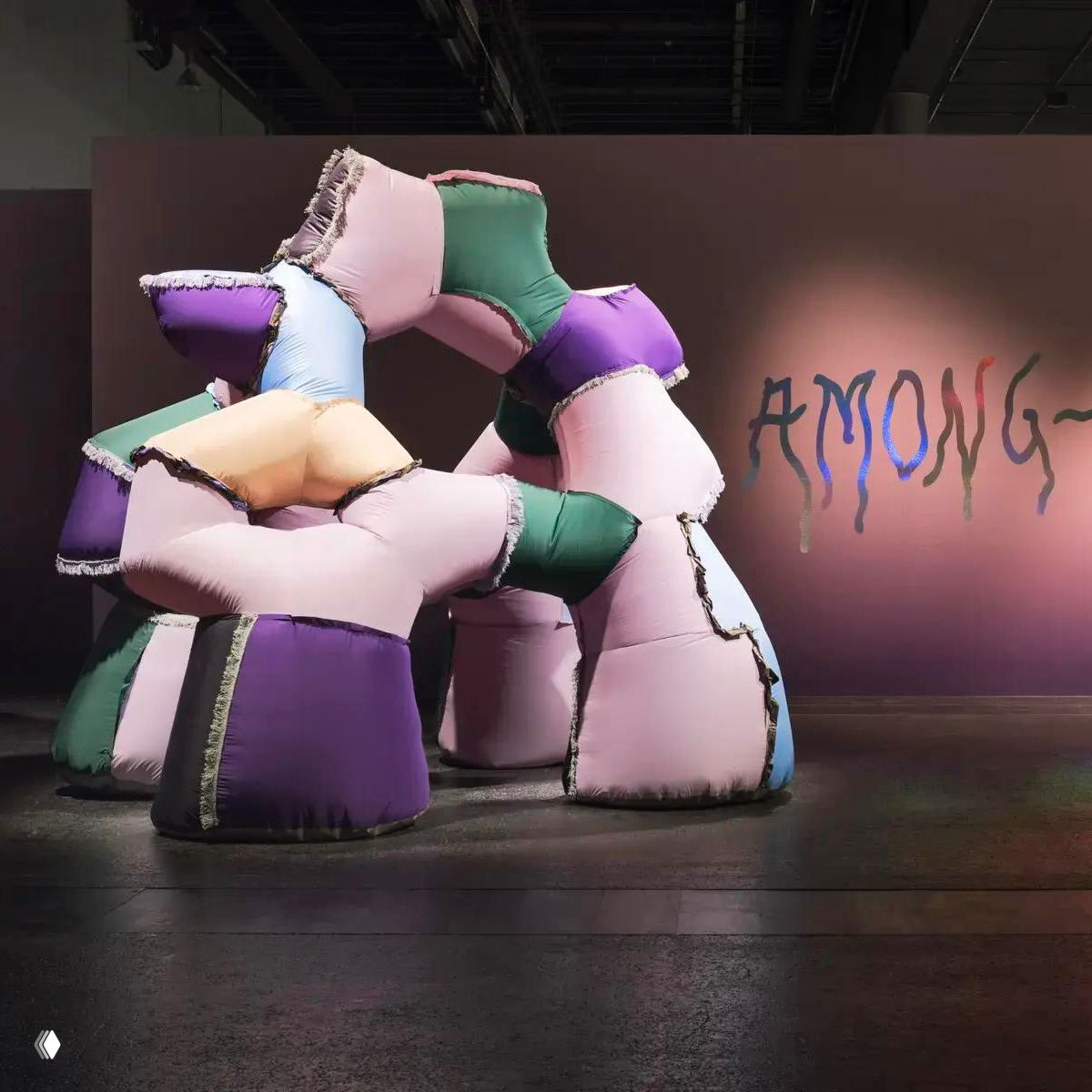 Пастельные модульные формы из переработанного текстиля в инсталляции «Среди всего»: розовые, фиолетовые и зелёные мягкие объёмы, собранные в арку.