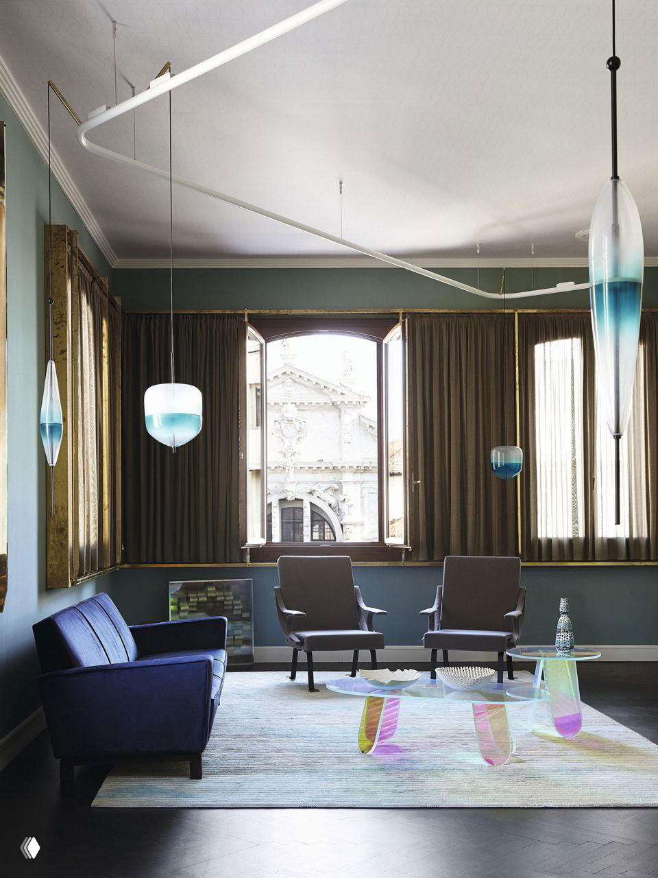 Интерьер с узкими высокими окнами и мягким бархатным оливковым диваном, золотыми акцентами и круглым журнальным столиком из стекла.