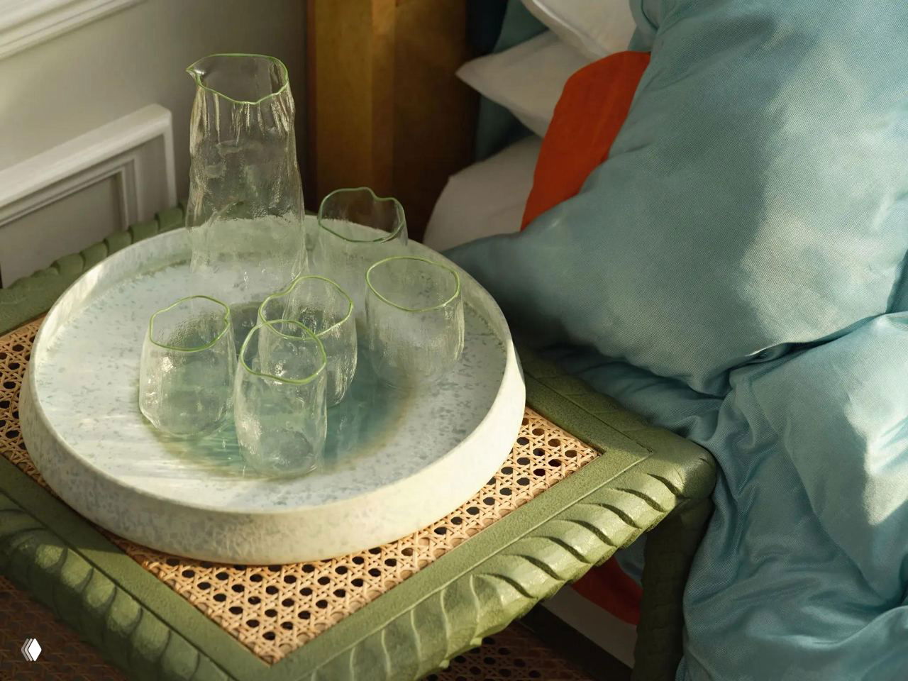 Крупный план стеклянной посуды и подноса на прикроватной тумбе: прозрачные сосуды с зелёным отливом в интерьере Celadon Suite.