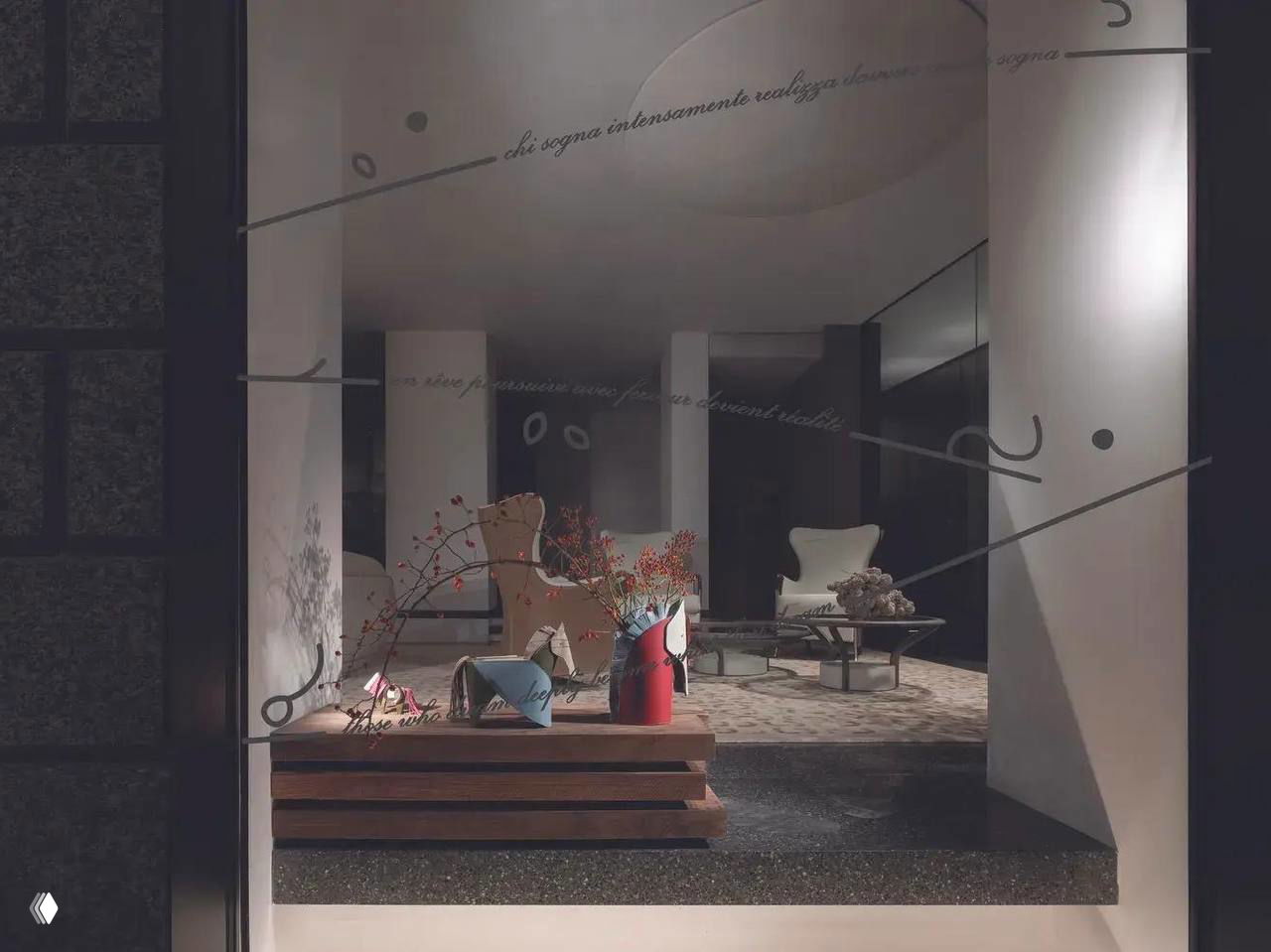 Витрина с экспозицией коллекции Nuvola: кожаные аксессуары в форме лошадей на фоне интерьерной сцены и мебели бренда.