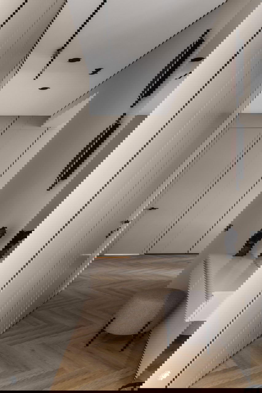 Прихожая с монохромными встроенными панелями и дверями, длинным коридором и паркетом «ёлочкой», минималистичный консольный столик и пуф в проекте Жанны Бондаренко.