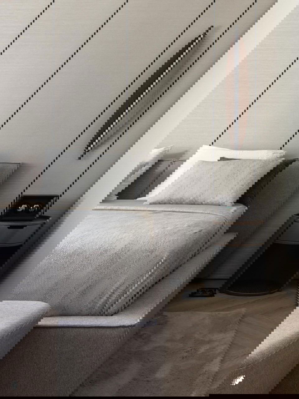 Спальня с большой серой кроватью, нюдовым текстилем и вертикальными панелями на стене; мягкая уютная атмосфера в проекте Жанны Бондаренко.