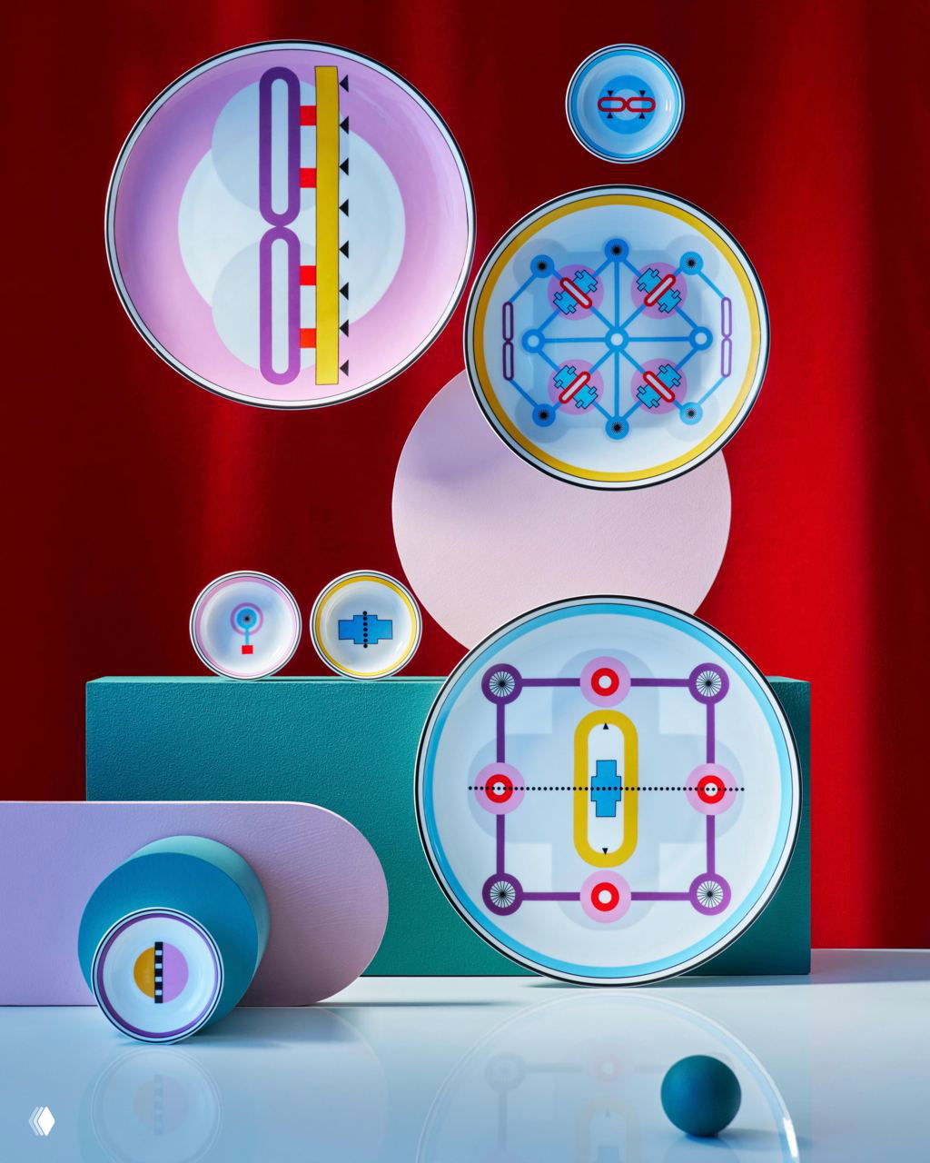 Композиция декоративных тарелок и круглых элементов на подставках: яркие графические узоры на контрастном фоне