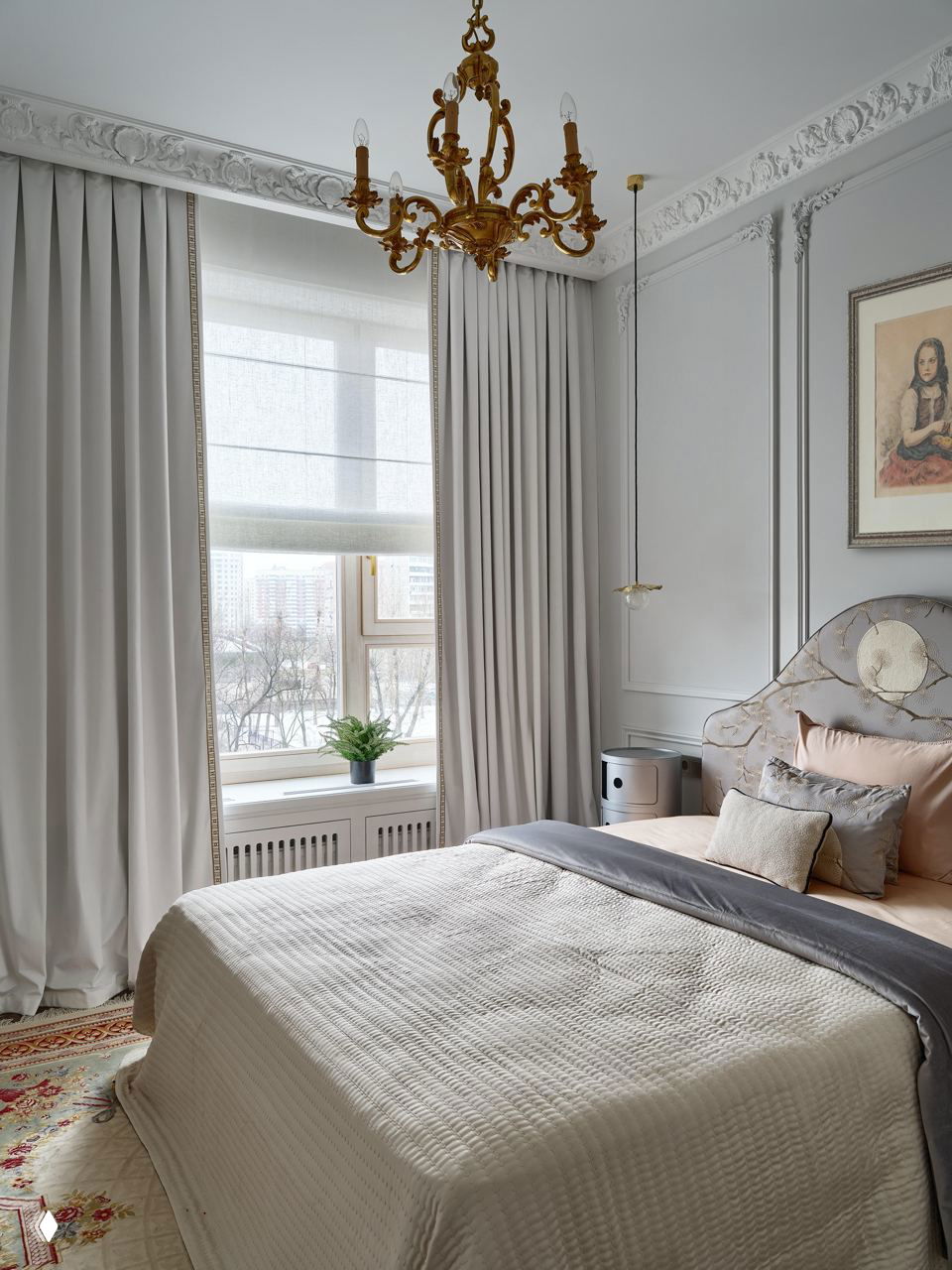 Спальня в светлых тонах с фигурным изголовьем кровати, плотными шторами и винтажным ковром у изножья — спокойная и уютная атмосфера.