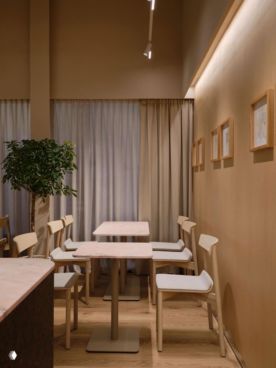Зона посадки с небольшими столиками и лёгкими деревянными стульями, нейтральные текстильные полотна на окнах и приглушенное освещение для спокойной атмосферы.