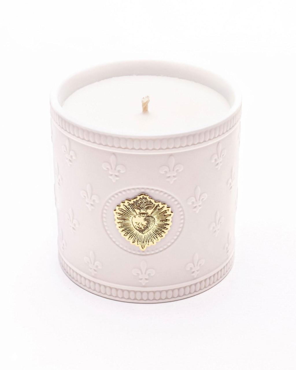 Белая ароматическая свеча в фарфоровой ёмкости с тиснением и золотым сердцем на крупном плане, нейтральный фон