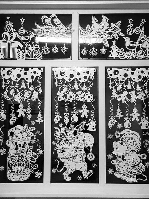 Несколько панелей вытынанок на тёмном фоне с изображениями Деда Мороза, игрушек и гирлянд, плотная композиция праздничных вырезок.