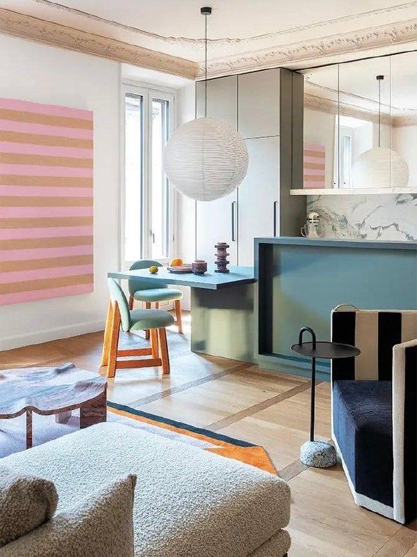 Открытая гостиная-кухня в разбелённых пастельных тонах: бирюзово-голубой бар и стол, мягкие стулья, полосатая настенная живопись и светлый паркетный пол