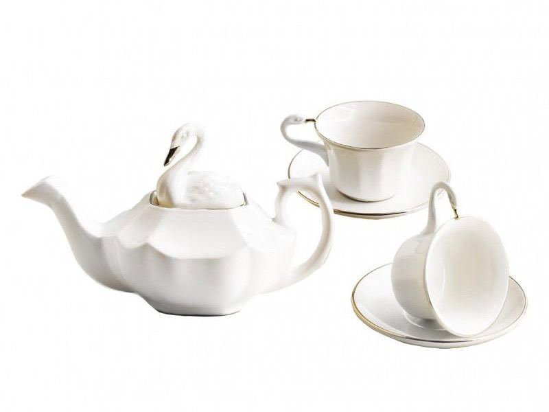 Белая чайная пара и чайник Cartuja de Sevilla на нейтральном фоне, минималистичный дизайн фарфора с золотым кантом, крупный план элементов сервиза.