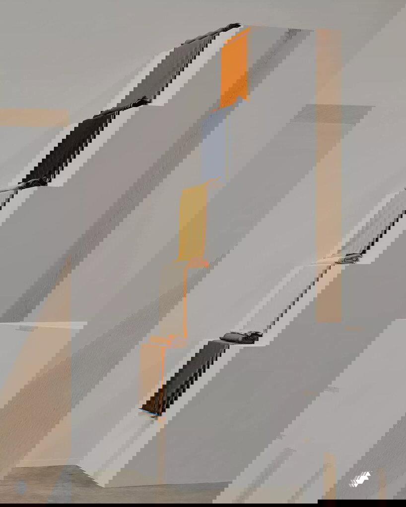 Ступенчатая композиция из белых буковых подиумов с аккуратно сложенными кашемировыми пледами разных оттенков в инсталляции Hermès.