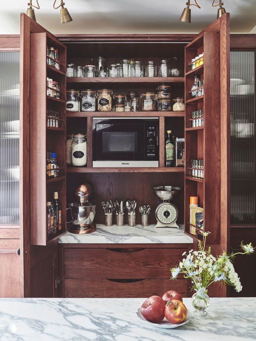 Встроенный тёмный шкаф-буфет с микроволновкой и полками для специй и сыпучих продуктов — компактное решение для хранения бытовой техники.