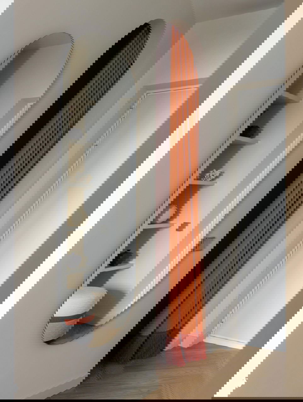 Прихожая с длинным овальным зеркалом и насыщенными оранжевыми шторами в арочном проёме; аккуратный минимализм и текстурные акценты.