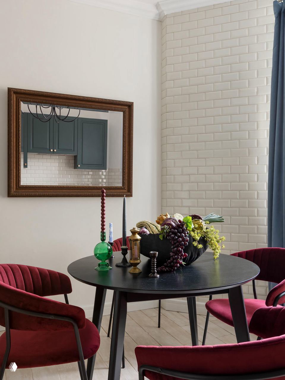 Обеденная зона с круглым чёрным столом, бордовыми стульями и декоративной фруктовой композицией — стилизованный натюрморт в московской сталинке.
