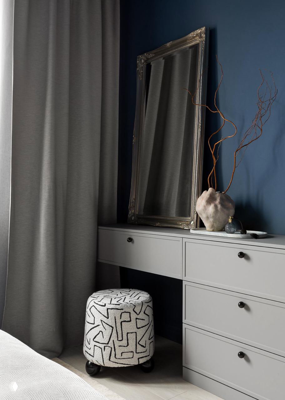 Комод и зеркало в спальной зоне: серый комод, большое декоративное зеркало и бархатный пуф — акцентная зона и аксессуары в московской сталинке.