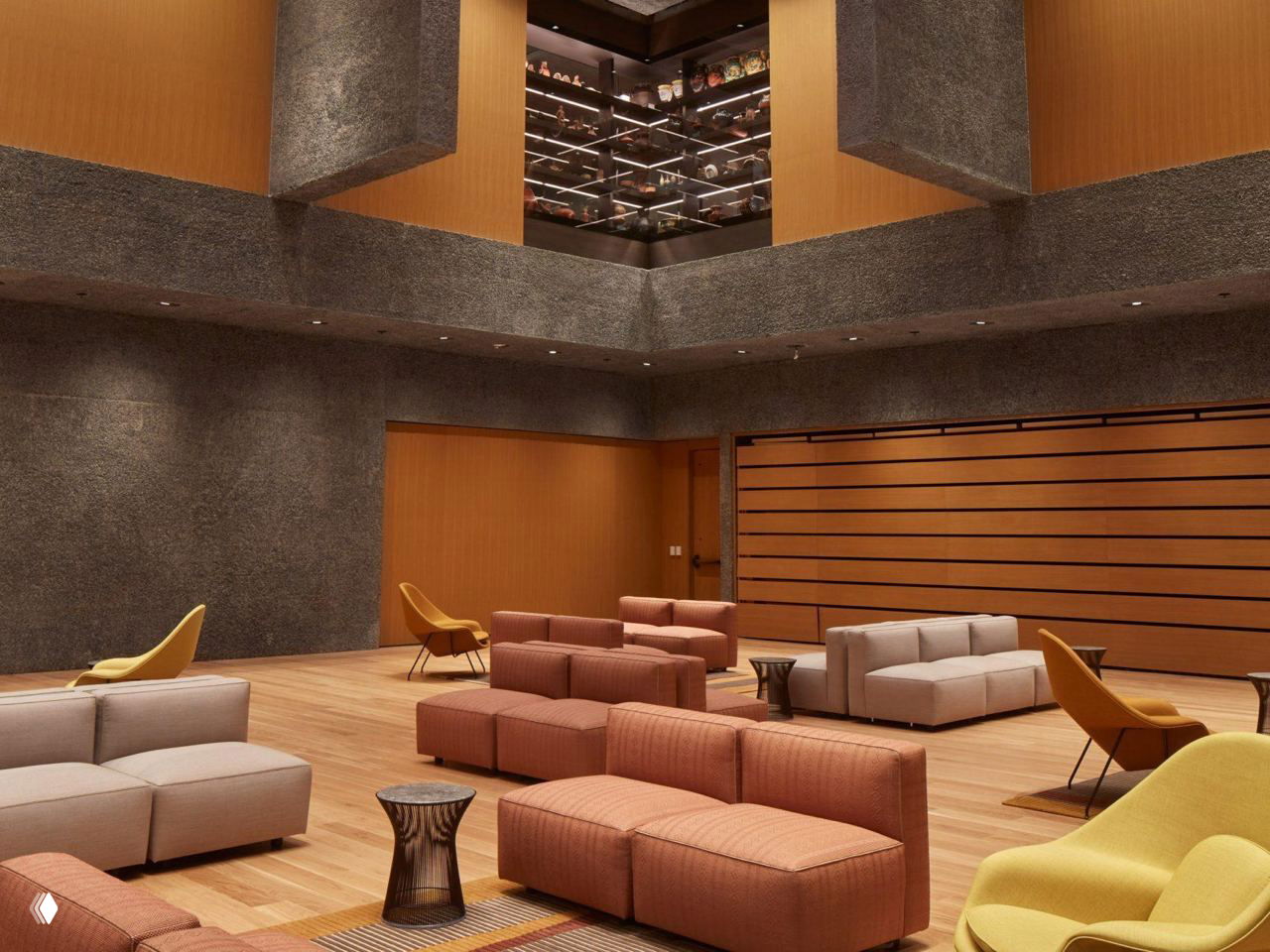 Мезонин и зал музея: деревянные полы и мебель в теплых тонах, крупные балки и фактурный бетон на стенах создают контраст.