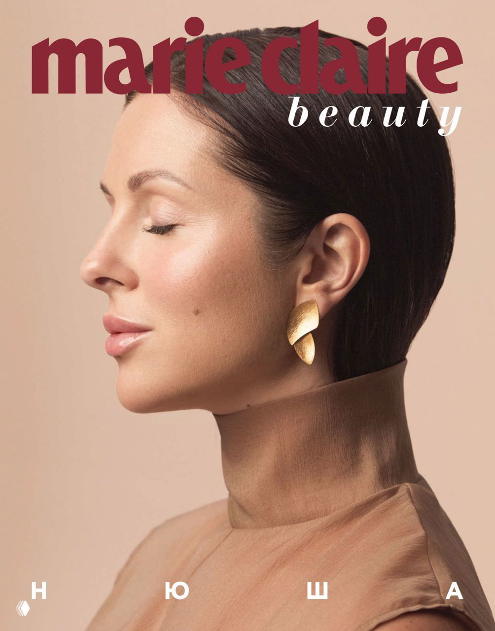 Обложка Marie Claire Beauty: профиль певицы Нюши с аккуратным макияжем и золотыми серьгами на бежевом фоне, тема бьюти и уход.