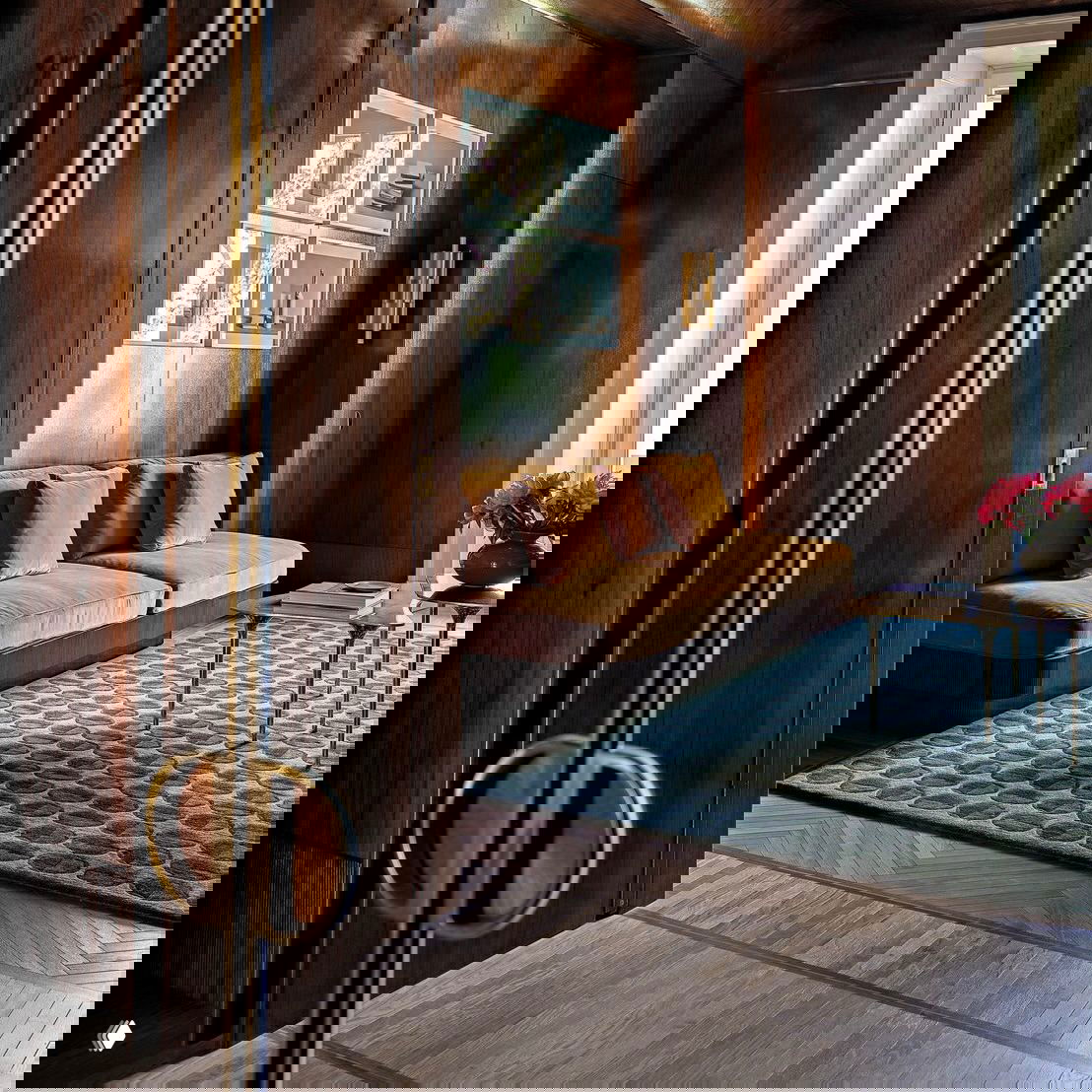 Спальня проекта Studio Dragó: тёмно-синие стены, минималистичная кровать с бордовым изголовьем и художественная графика над ней.