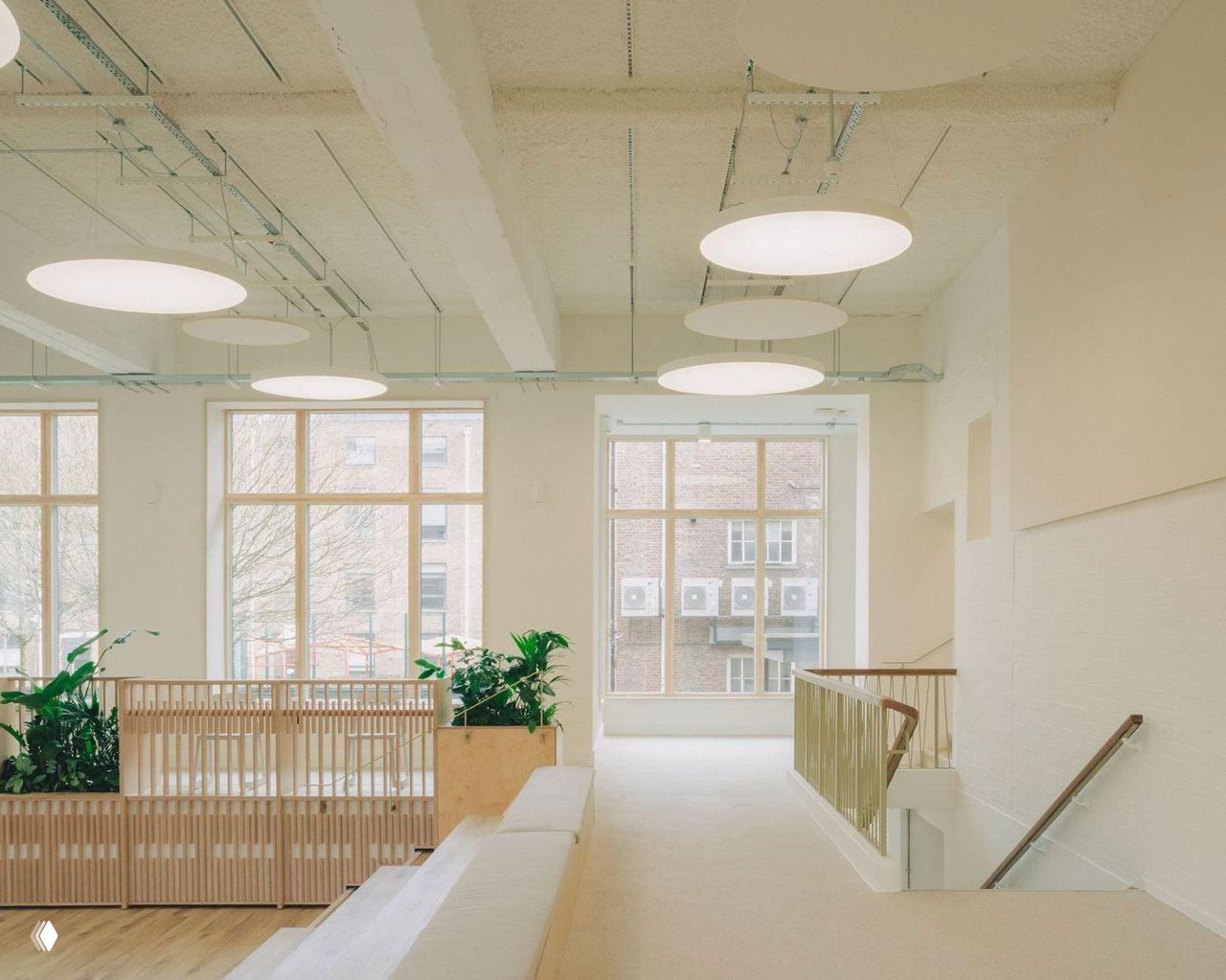 Музыкальная и презентационная зона внутри учебного центра: сценка с микрофоном, стойками и аккуратной отделкой светлым деревом и белыми стенами.