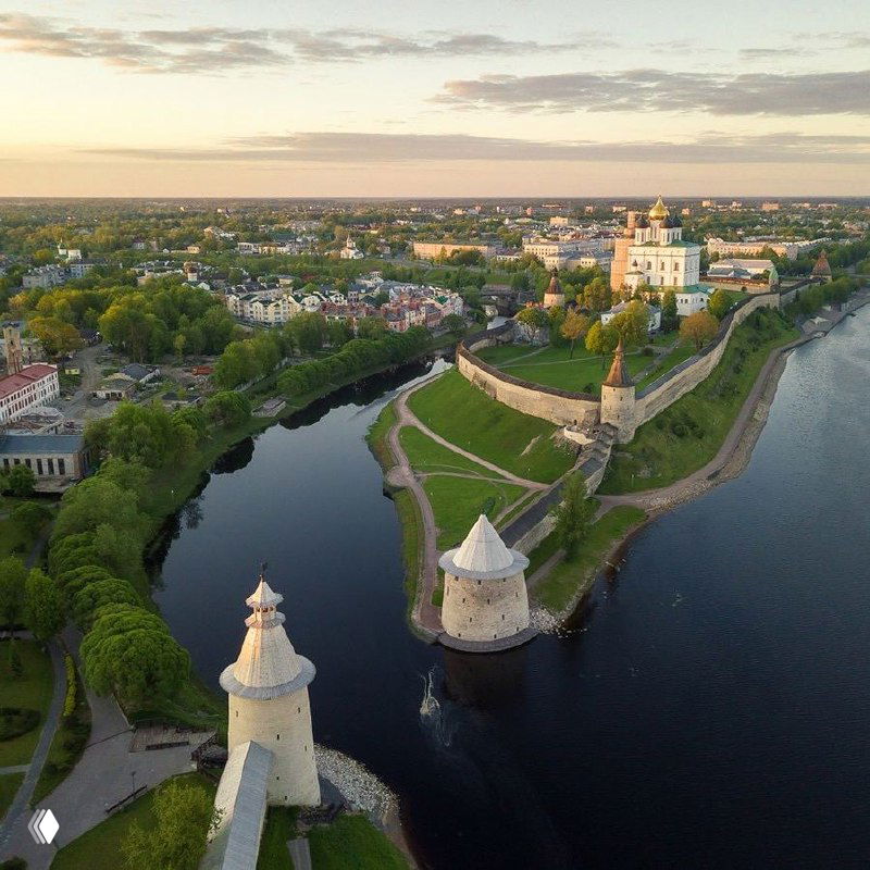Панорамный вид на Псков и реку Великую с высоты птичьего полёта; изображение частично искажено цифровыми артефактами, видны стены кремля.