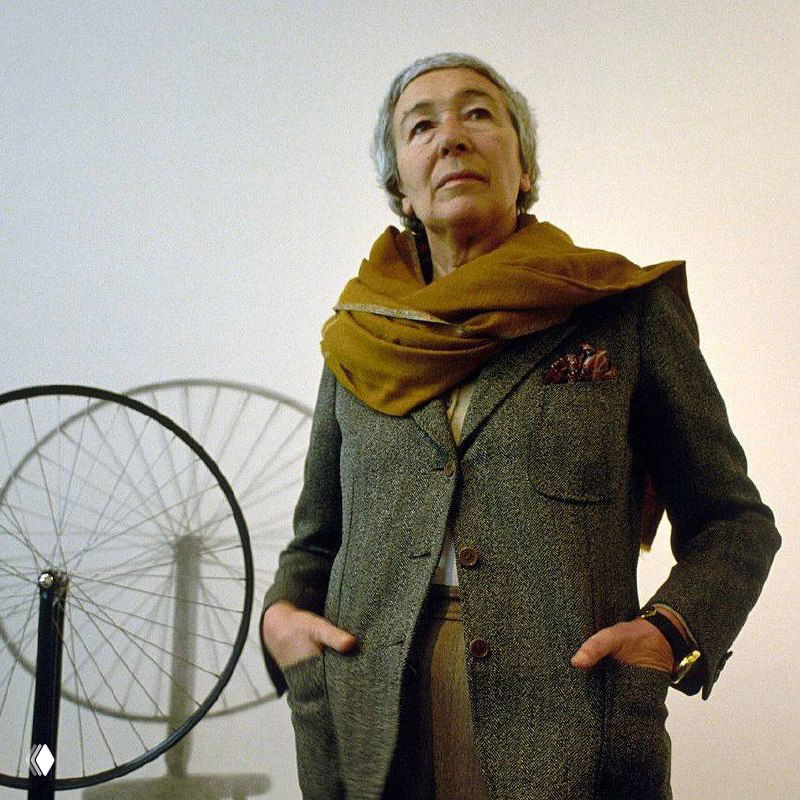 Чёрно-белое искажённое изображение: крупный план дизайнера рядом с колесом велосипеда, цифровые артефакты и контрастный фон