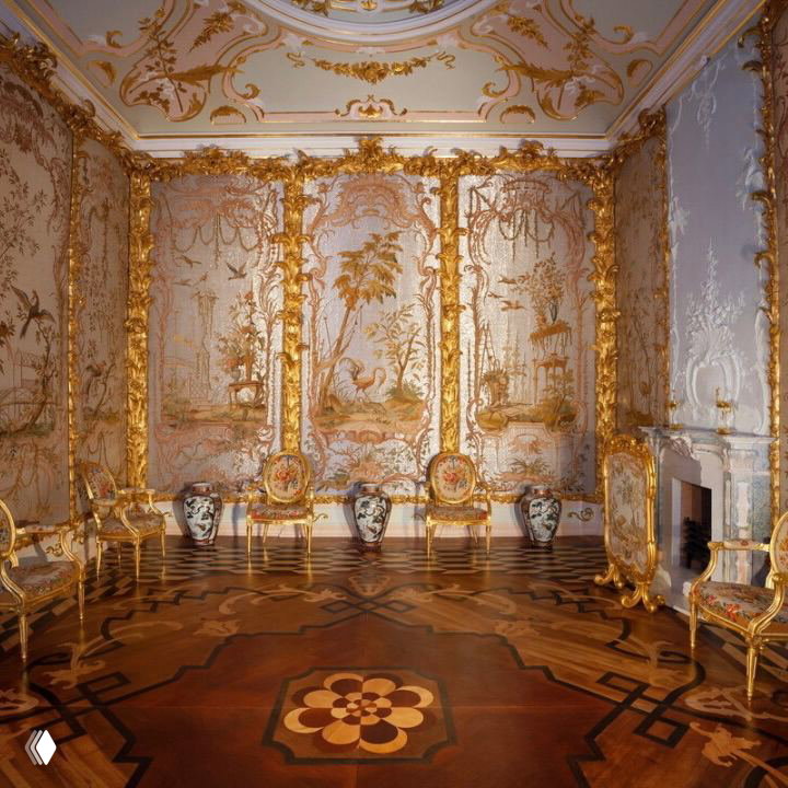 Общий вид Стеклярусного кабинета Китайского дворца: высокие панно с изображениями пейзажей, позолоченные рамы и паркет с геометрическим орнаментом в историческом интерьере.