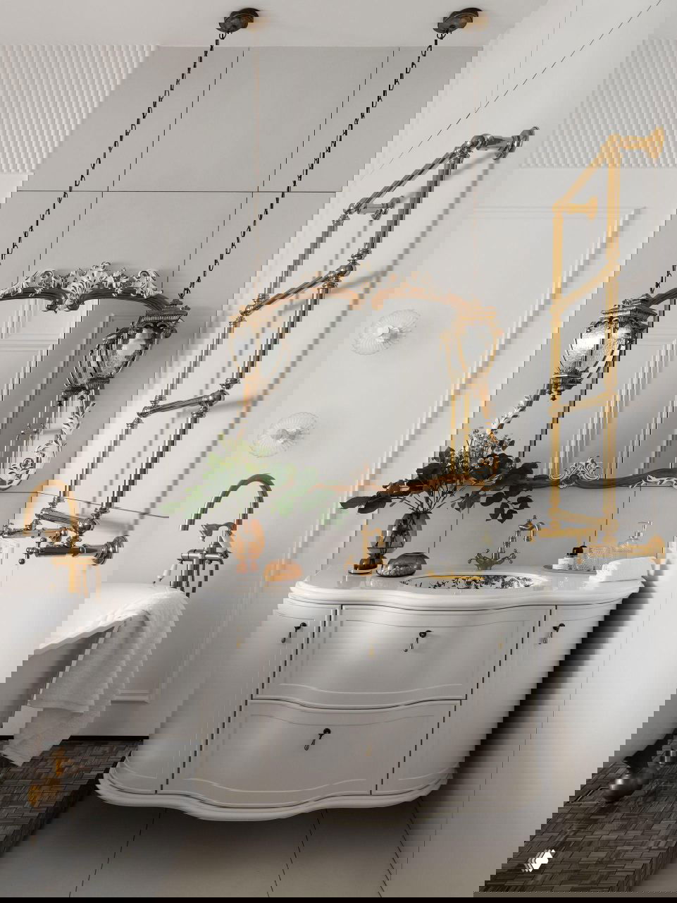 Ванная комната в духе современной классики: фаянсовая тумба со столешницей, позолоченные смесители, зеркало в резной раме и декоративные подвесные светильники над раковиной.
