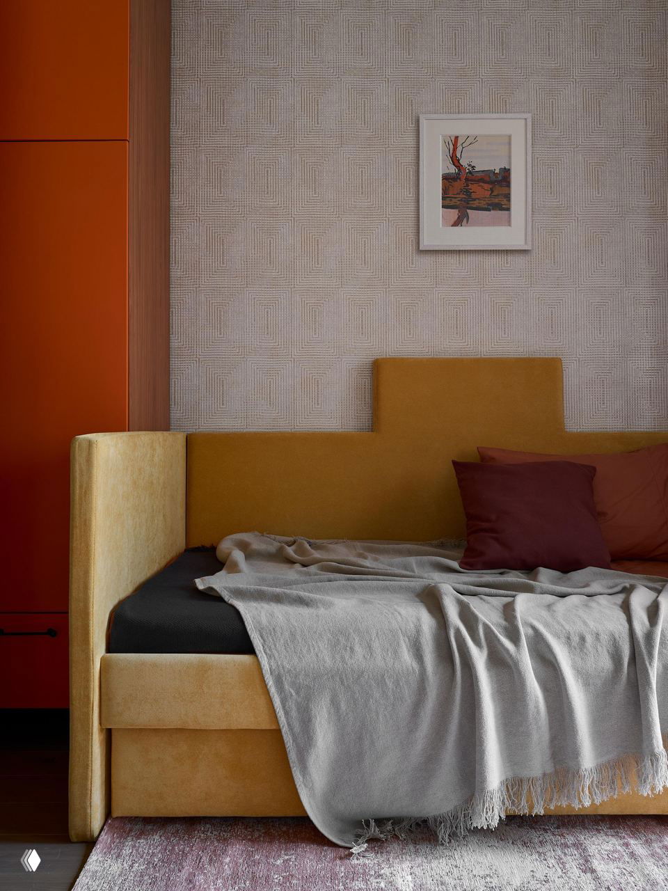 Кровать и мягкая обивка в спальне: горчичные и терракотовые акценты, минималистичное изголовье и текстильный ковёр создают уютную атмосферу.