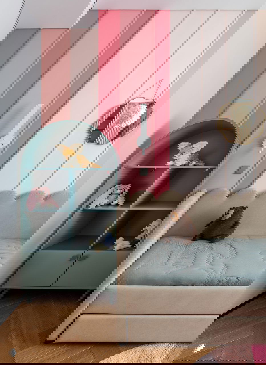 Детская с пастельными панелями на стене, бирюзовым шкафчиком в форме домика, мягкой кроватью и игрушками на полках