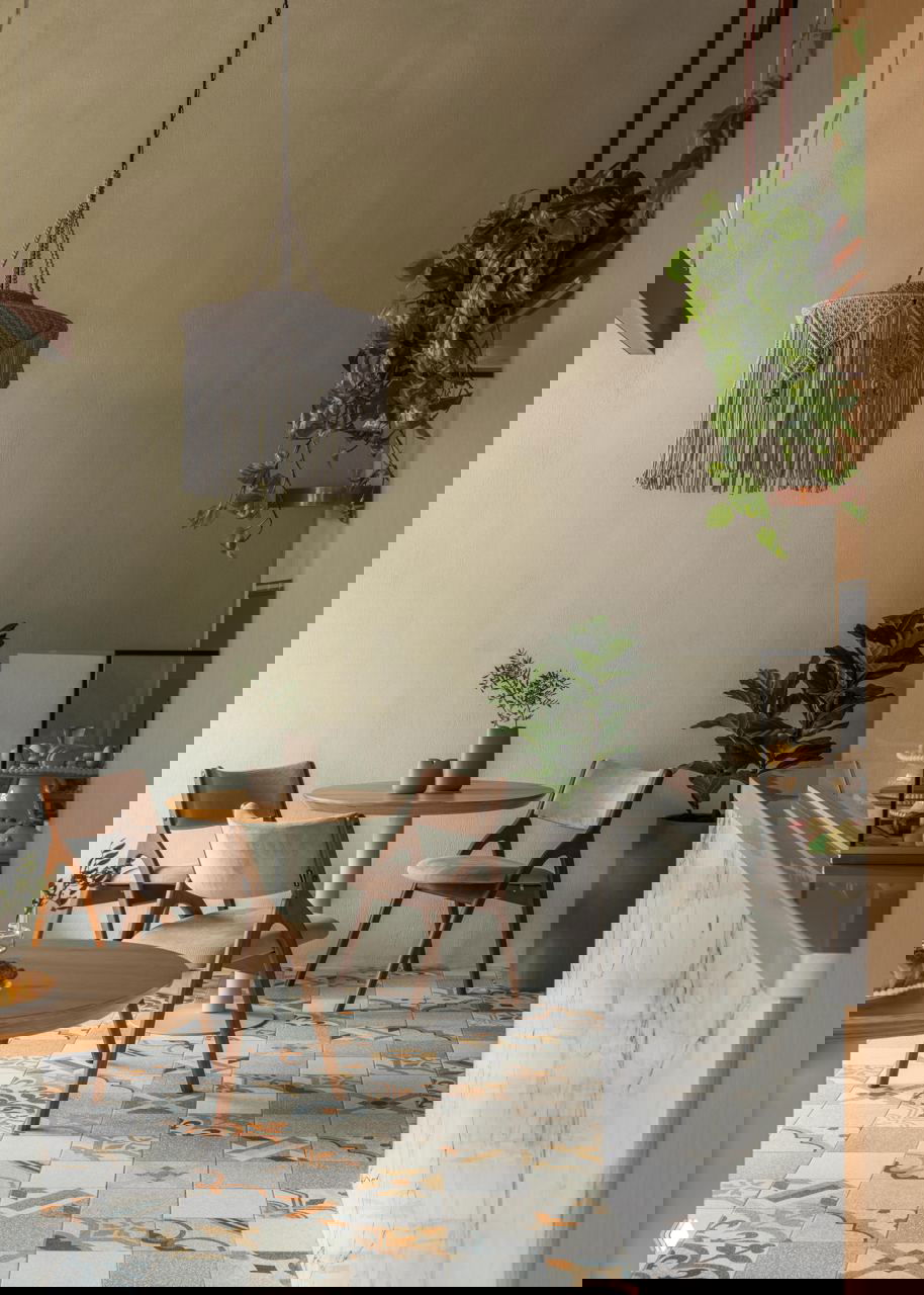 Макраме-светильник над столиком, растения в горшках и аккуратно подобранные детали интерьера с акцентом на натуральные текстуры и тёплые оттенки.