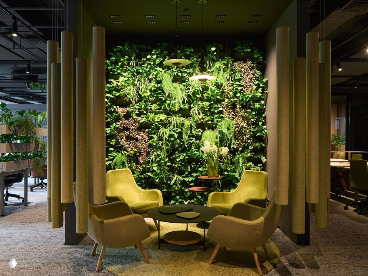 Зона переговоров с вертикальной зелёной стеной: кресла салатового цвета, декоративные подвесы и насыщенная растительность
