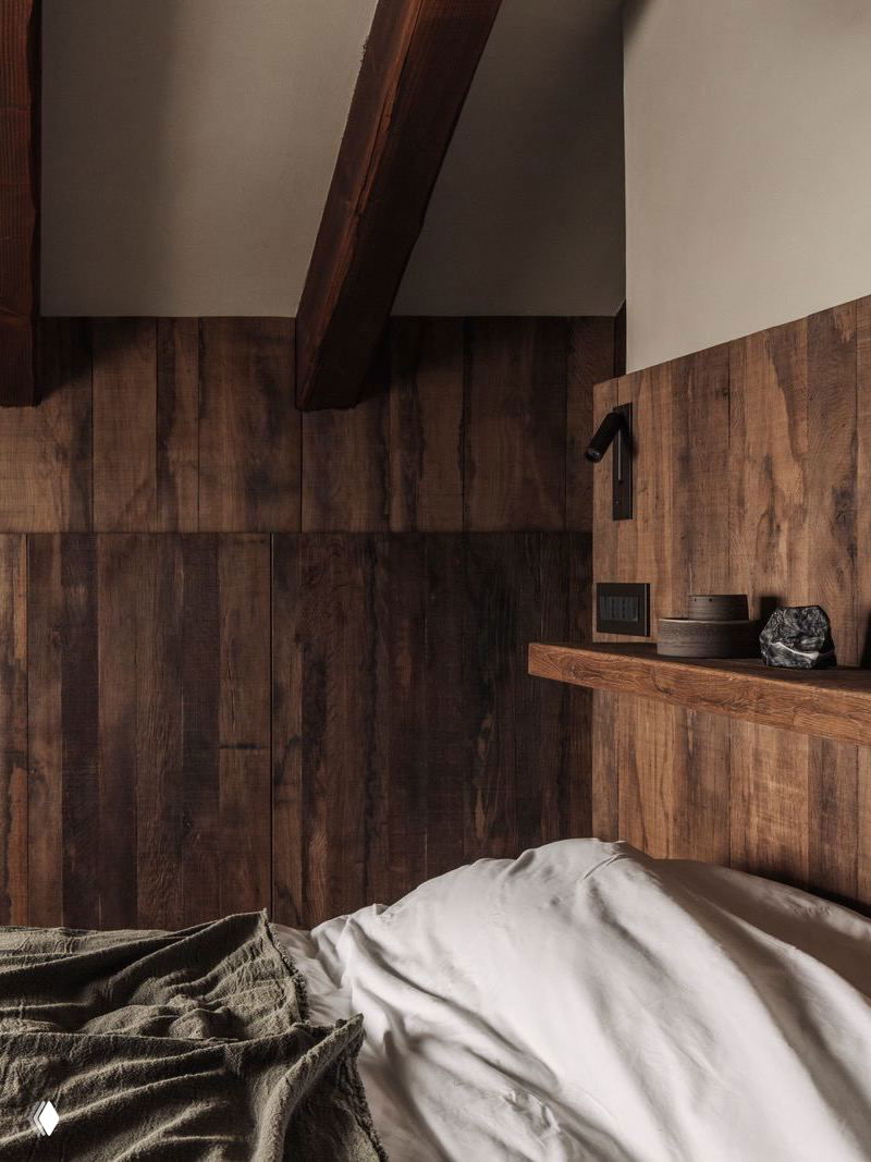 Спальня с тёплой отделкой из лиственницы и круглым арочным элементом над кроватью; текстиль нейтральных тонов и натуральные фактуры в интерьере.