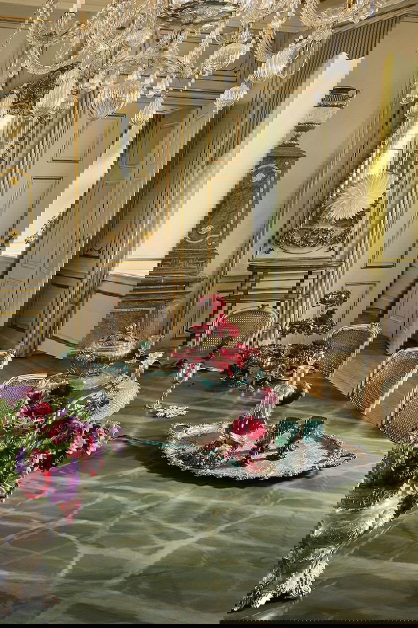 Столовая поместья с хрустальной люстрой и серебряными подносами: тщательно оформленный рождественский стол с вазами, декором и стеклянной посудой на Рождество в поместье на Фюне.