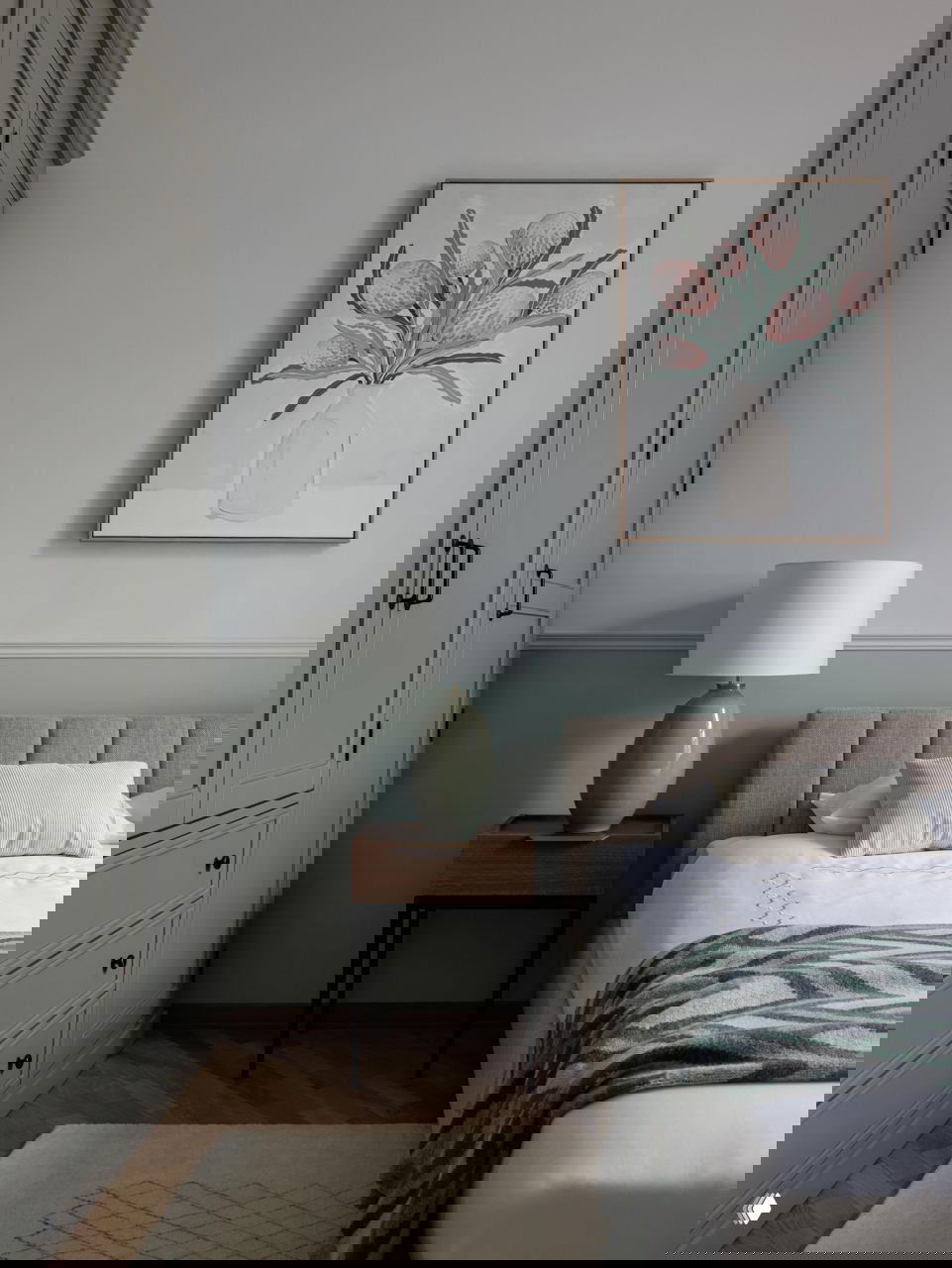 Интерьер спальни с большой арочной зеркальной панелью и прикроватной тумбой — отражения усиливают ощущение глубины и света в комнате.