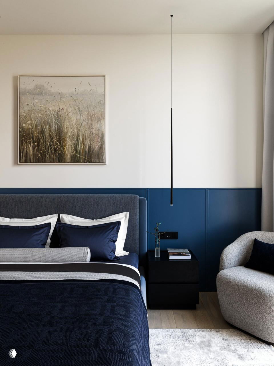 Спальня с синим панелированием стены, тёмно-синей постелью и мягким креслом, подчёркивающая синие акценты интерьера.